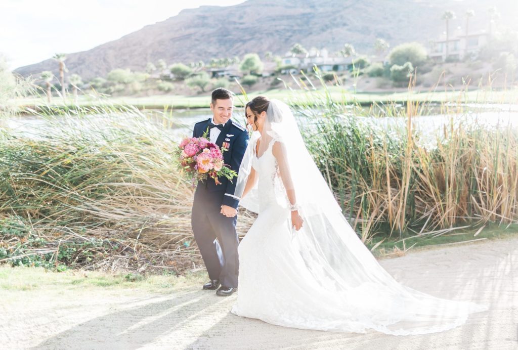 Couple walking in front of tall grass at  the Red Rock Canyon Country Club during their Las Vegas wedding shoot