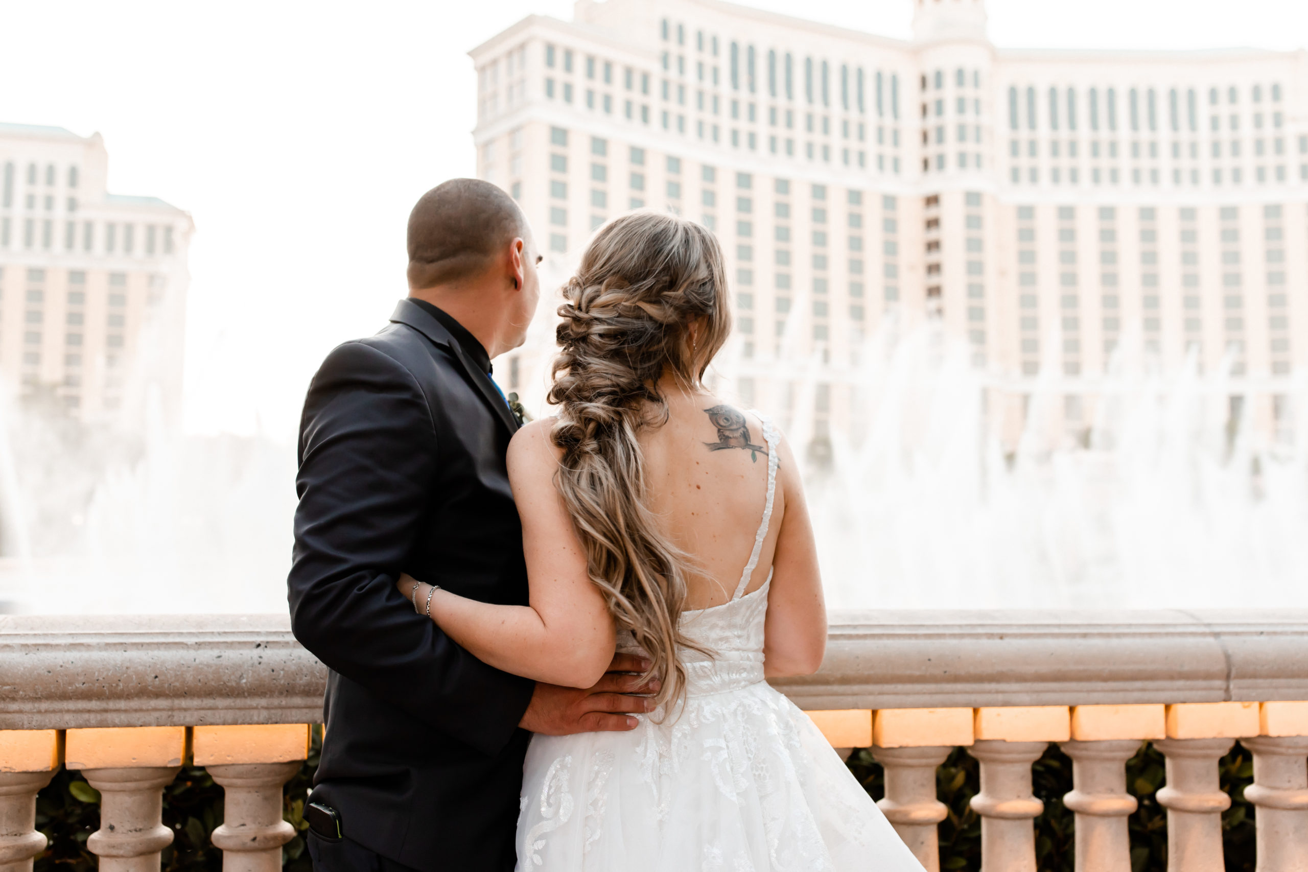 Newlywed couple sharing an embrace as they look out into the fountain during their elopement shoot with Elopement Las Vegas