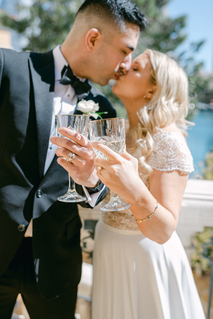 Bride and groom sharing a kiss and a toast during their elopement shoot with Elopement Las Vegas