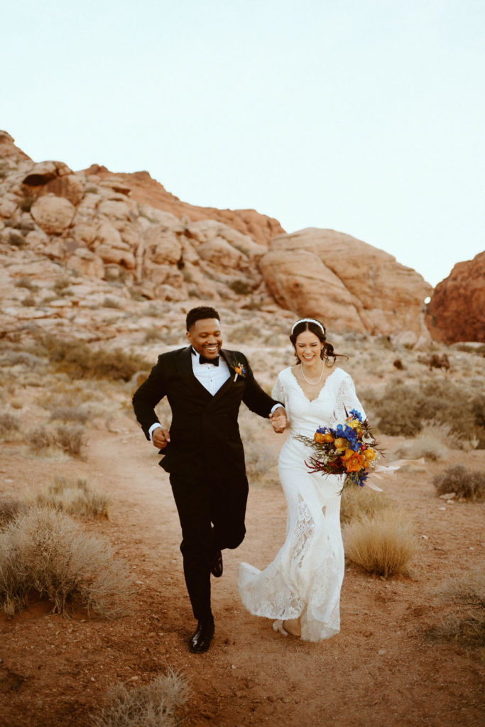 Newlywed couple running together during their wedding shoot at the canyon Off The Strip
