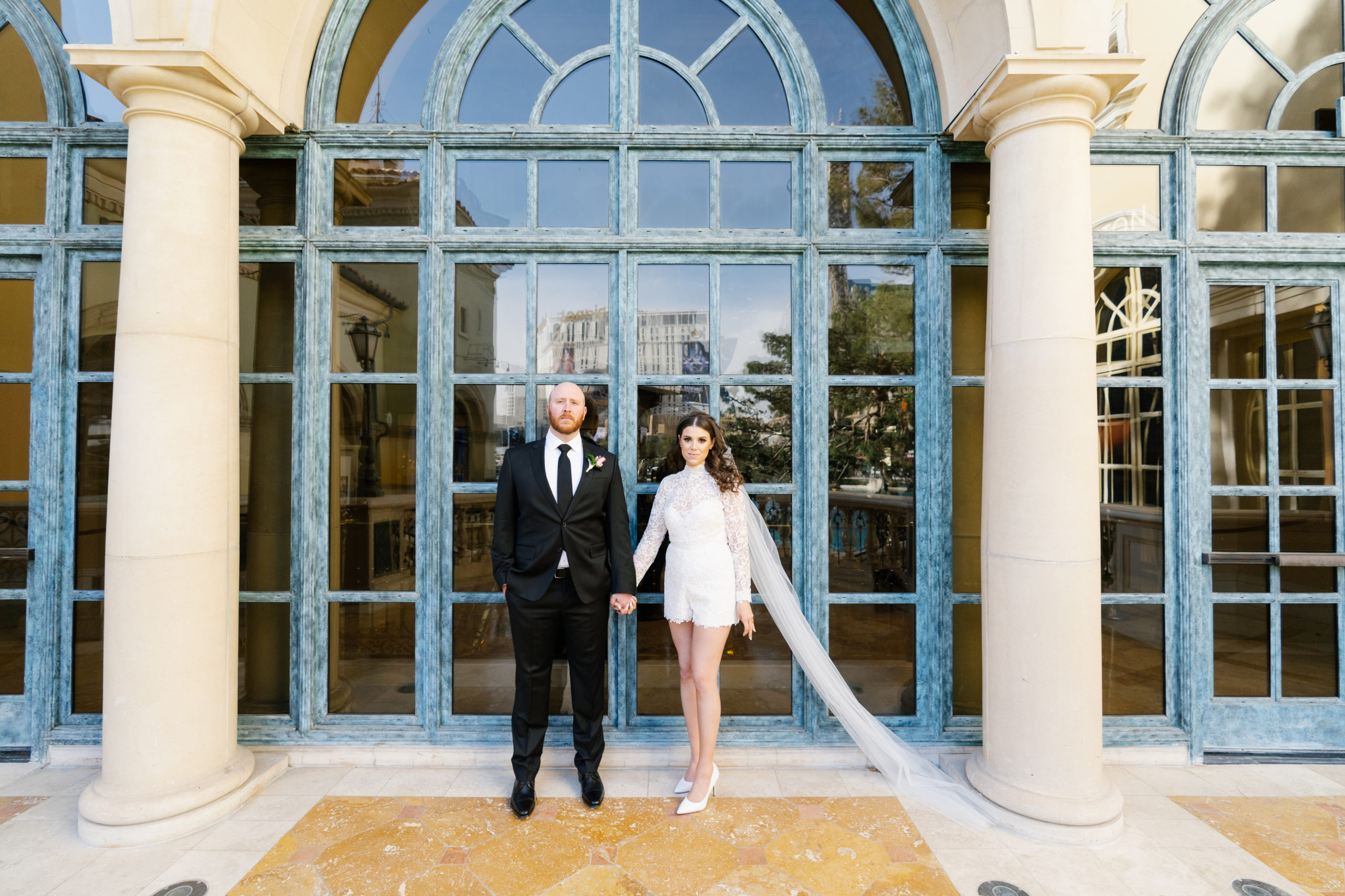 Bride and groom holding hands and posing outside The Bellagio in Las Vegas