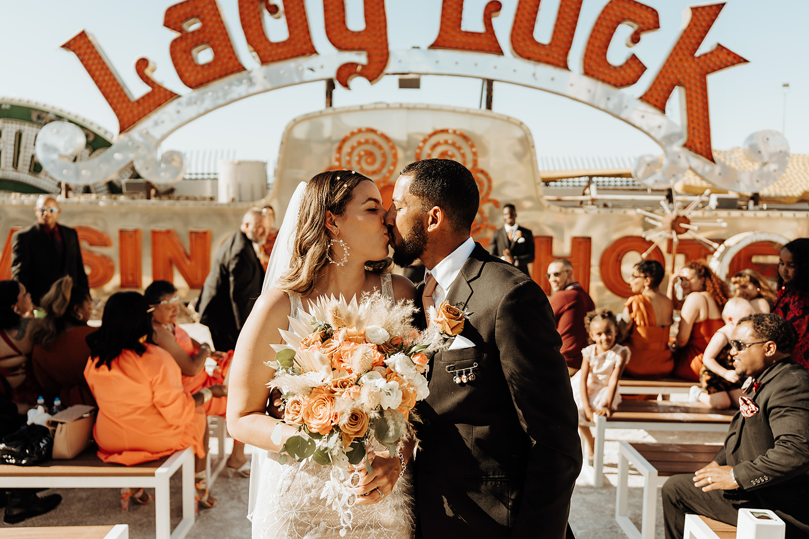 Couple sharing a kiss during their wedding ceremony at the Neon Museum arranged by Elopement Las Vegas