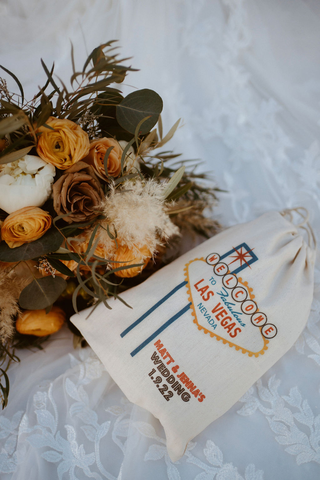Neon Museum Wedding & Elopement Package. Flat-lay shot of flowers and Welcome to Las Vegas bag.