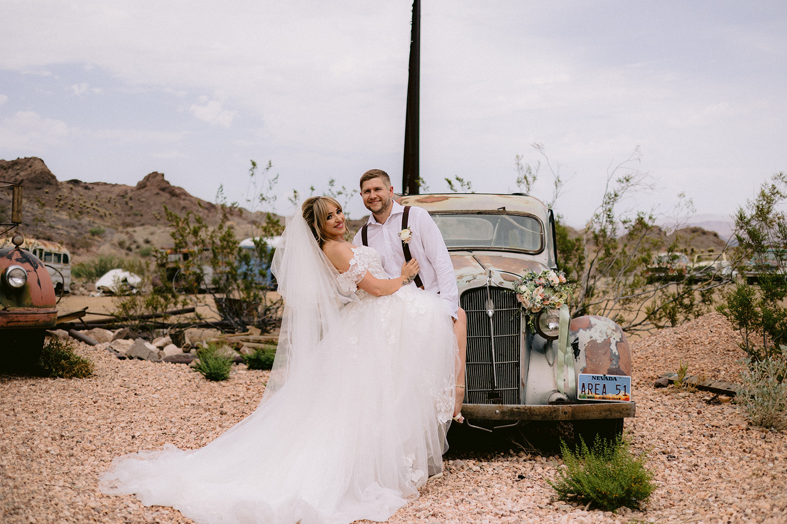 Nelson Ghost Town Wedding Packages (All-Inclusive). Bride and groom posing next to used cars.
