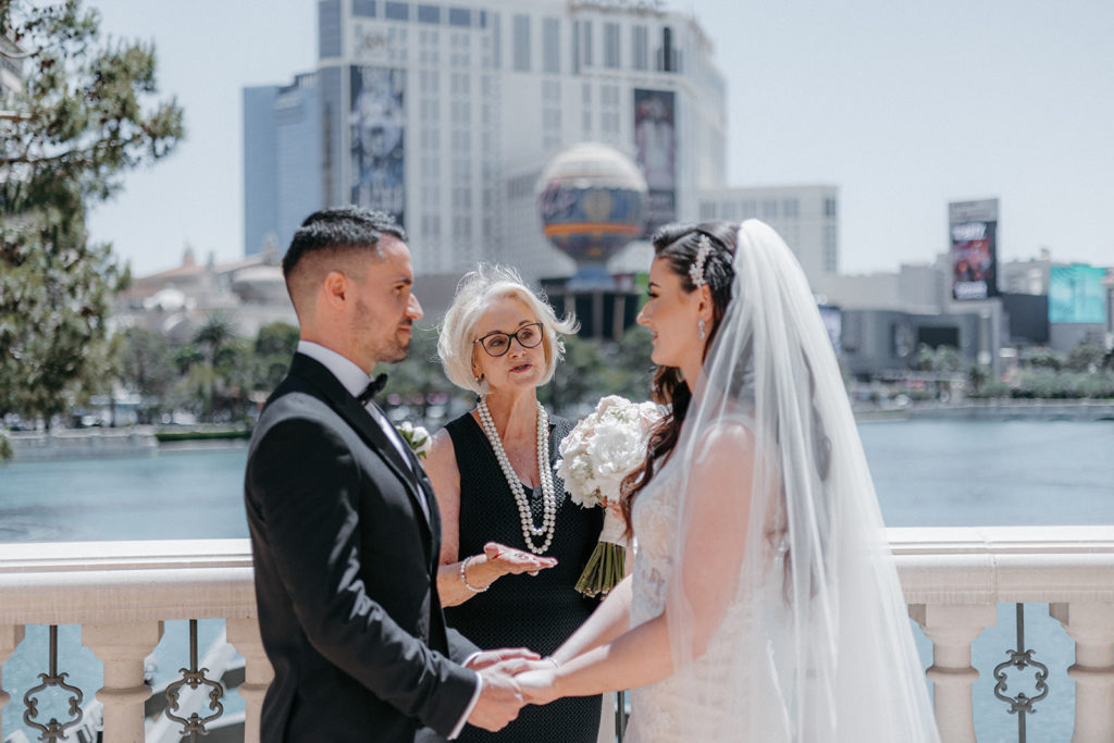 Bride and groom looking at each other and holding hands in front of officiant during their wedding in Las Vegas