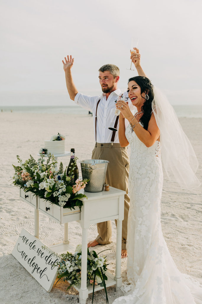 Bride and groom holding champagne glasses during their reception planned by Elopement Las Vegas