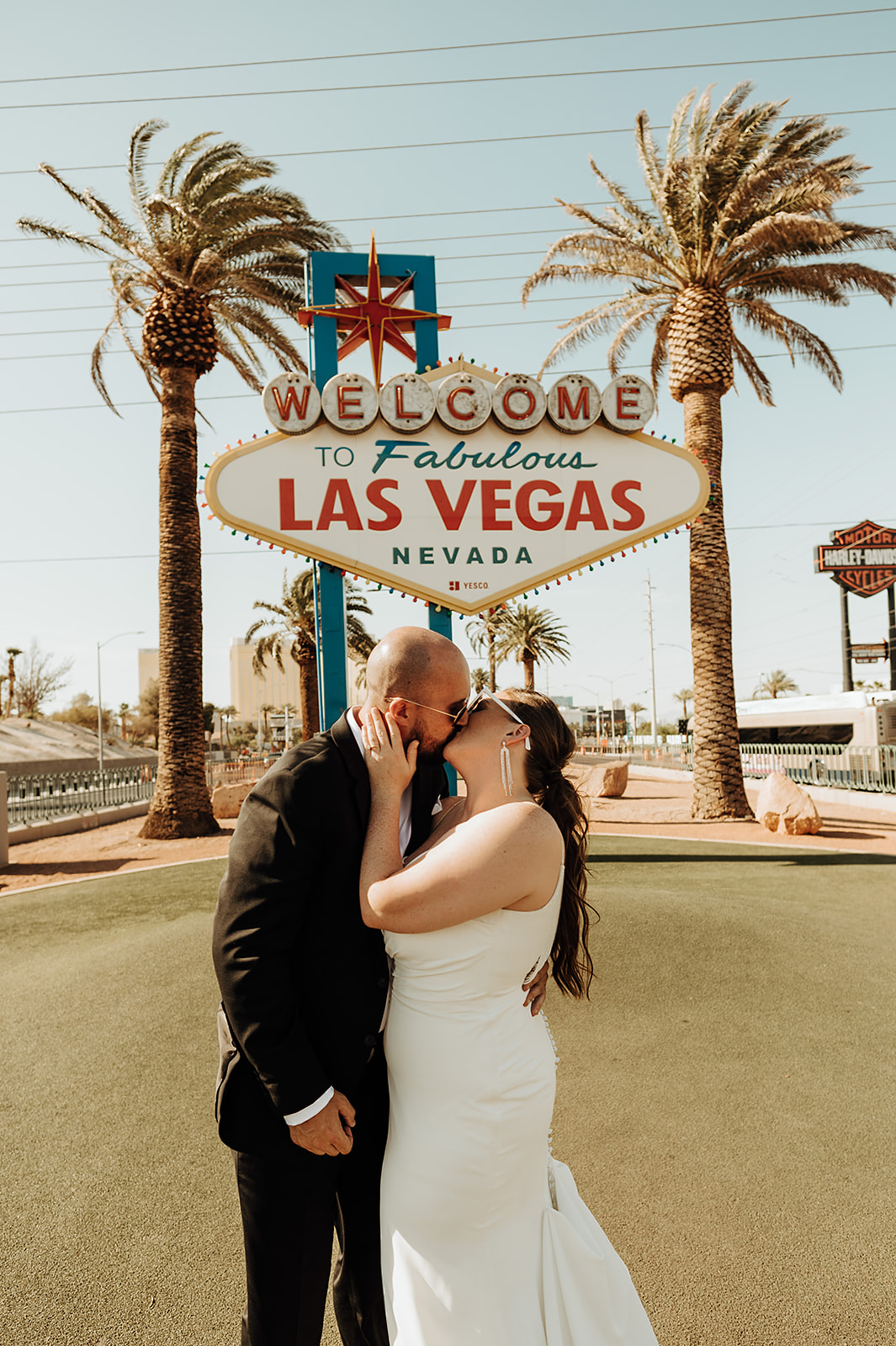 Bride and groom share a kiss in front of Las Vegas sign for their wedding shoot