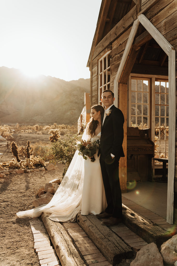 Bride and groom posing outside the chapel at Nelson Ghost Town