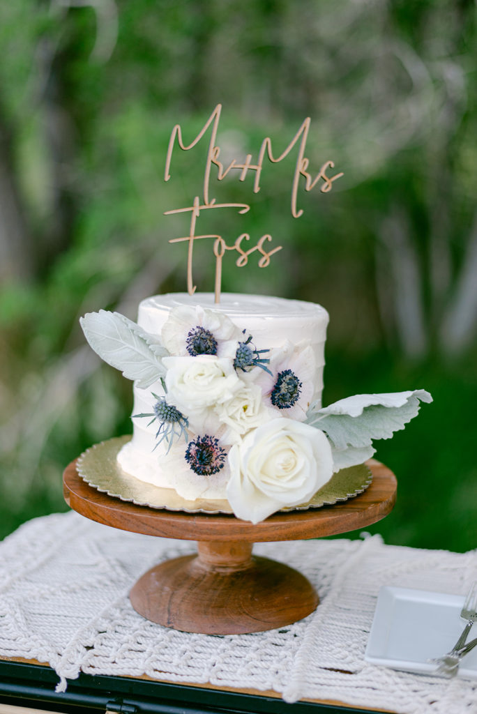 Wedding cake with floral design and cake topper, provided by Elopement Las Vegas