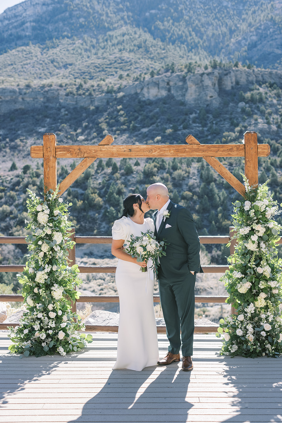 Couple sharing a kiss underneath their wedding arch at Mount Charleston, one of the best places to get married in Vegas