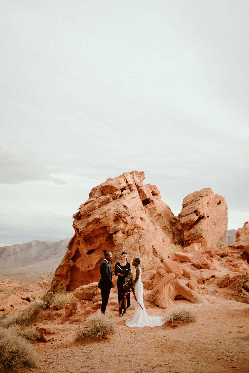 Valley of Fire Wedding & Elopement Planning Guide. Bride and groom standing in front of officiant.