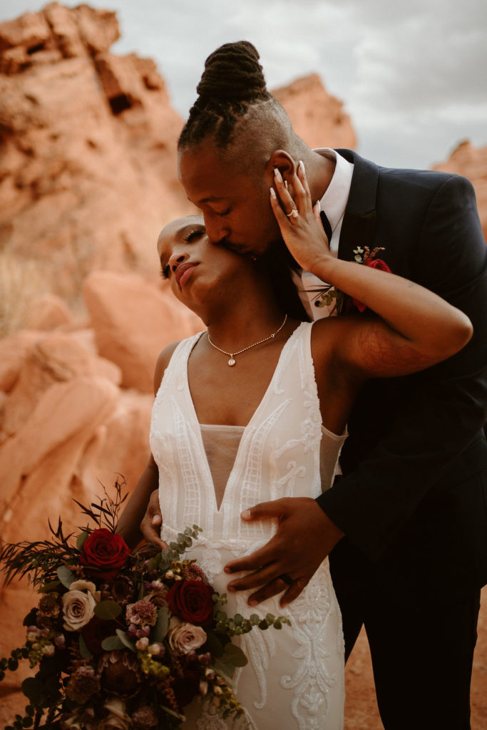Valley of Fire Wedding & Elopement Planning Guide. Groom hugs bride from behind during their elopement shoot.
