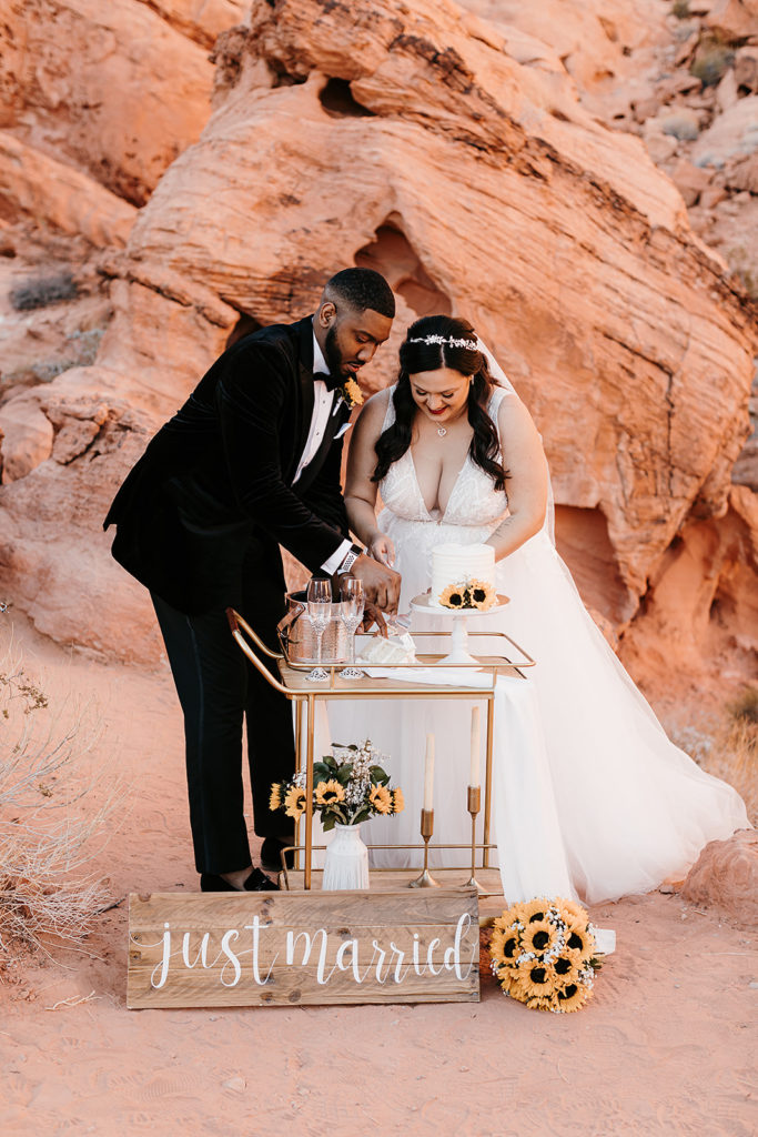 Valley of Fire Wedding & Elopement Planning Guide. Couple cutting a slice of their wedding cake.