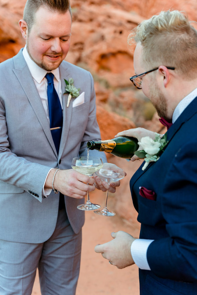 Valley of Fire Weddings - All-Inclusive Elopement Packages. Couple pouring champagne into glasses.