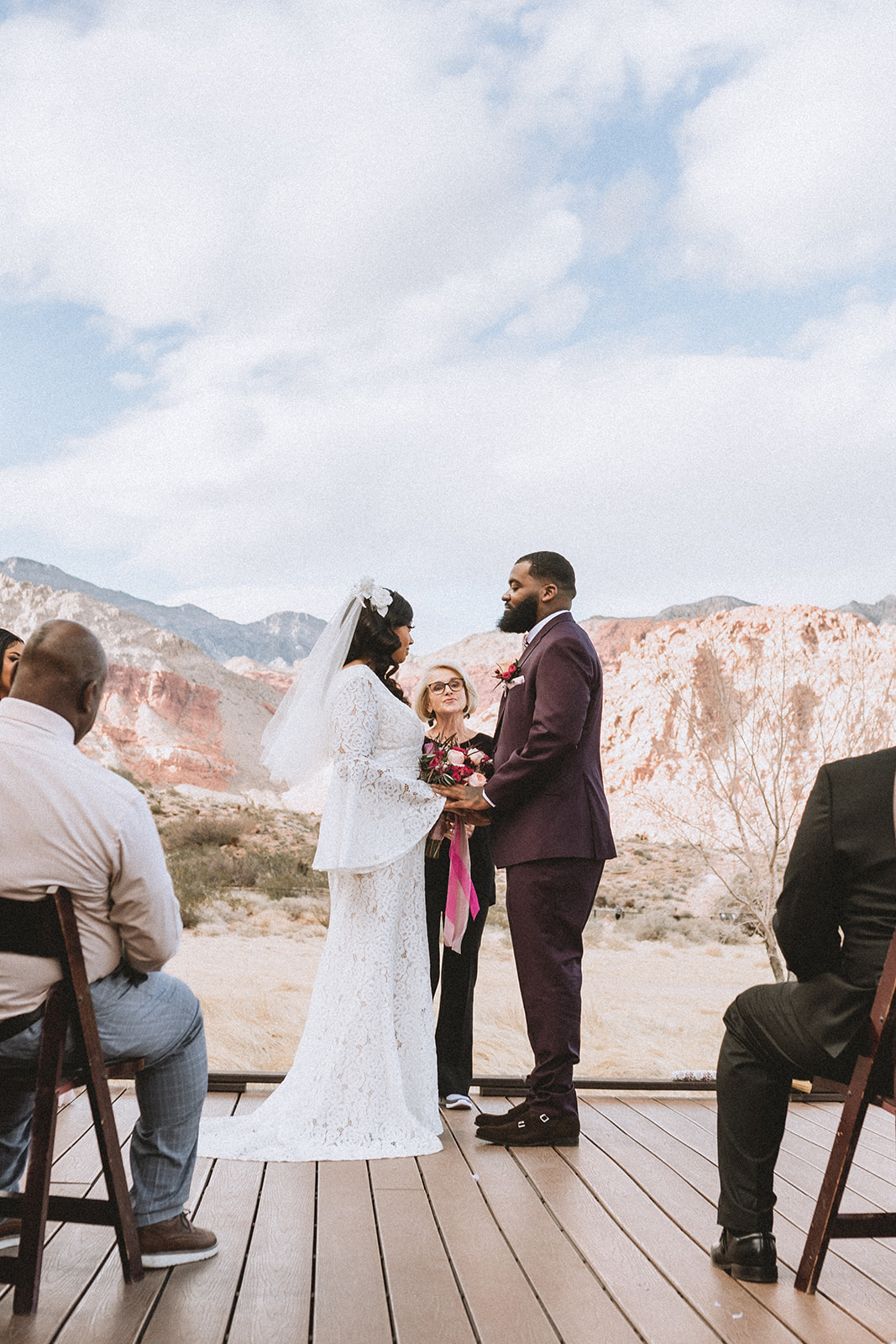 Couple holding hands in front of the officiant during their Red Rock Canyon Elopement Ceremony