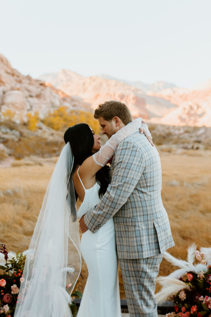 Bride and groom wrapping their arms around each other during their elopement shoot organized by Elopement Las Vegas