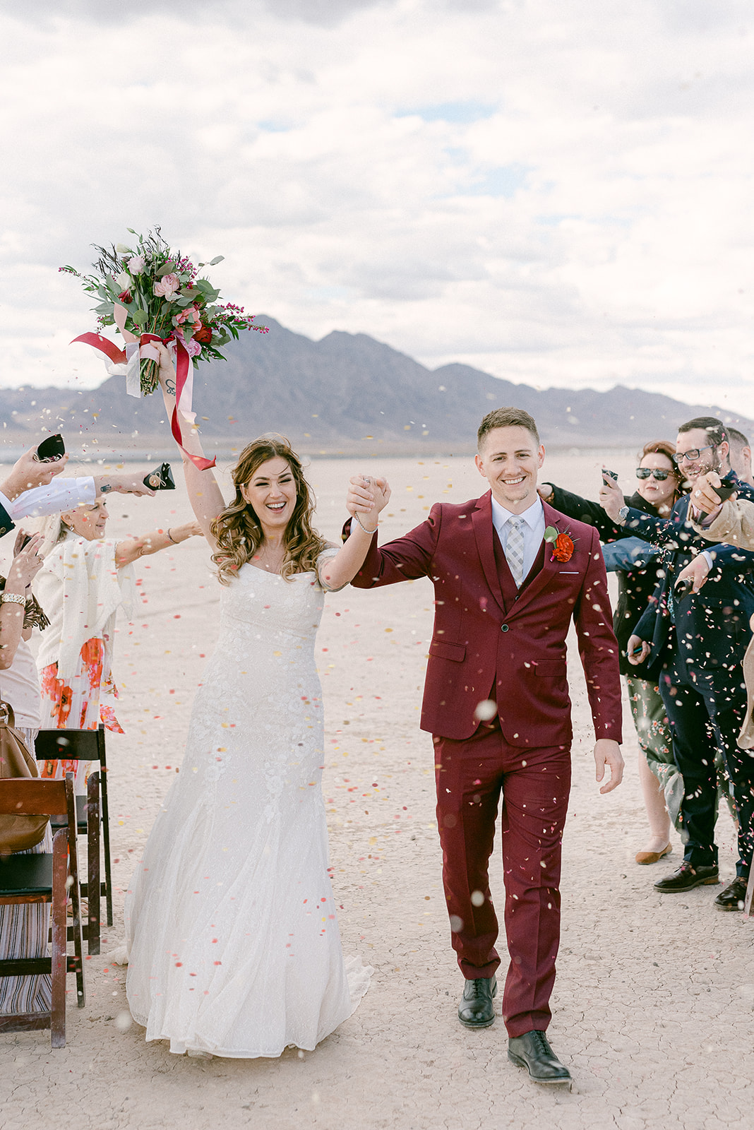 Spring Mountain Ranch Wedding & Elopement. Couple holding hands with guests showering them with flower petals.