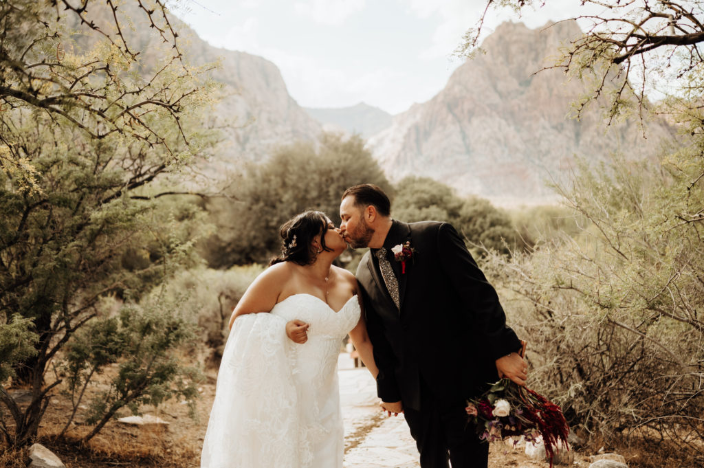 Newlywed couple sharing a kiss during their elopement shoot arranged by Elopement Las Vegas