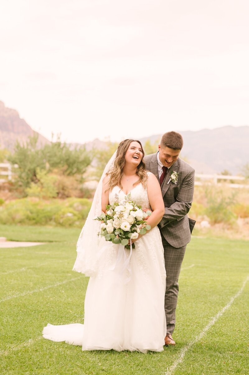 Groom hugging bride from behind as they candidly laugh during their Las Vegas elopement shoot