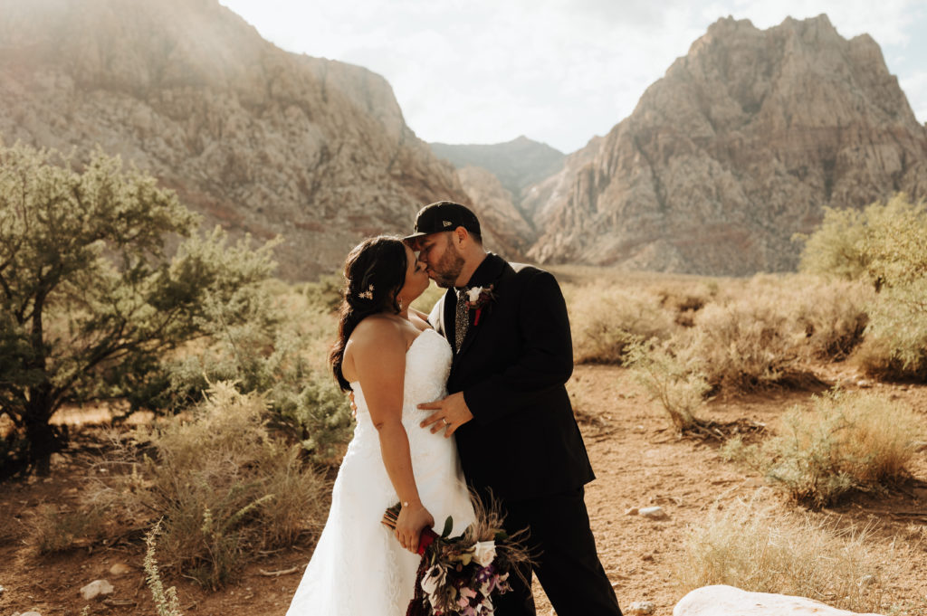 Spring Mountain Ranch Wedding & Elopement. Couple sharing a kiss during their shoot with mountains in the background.