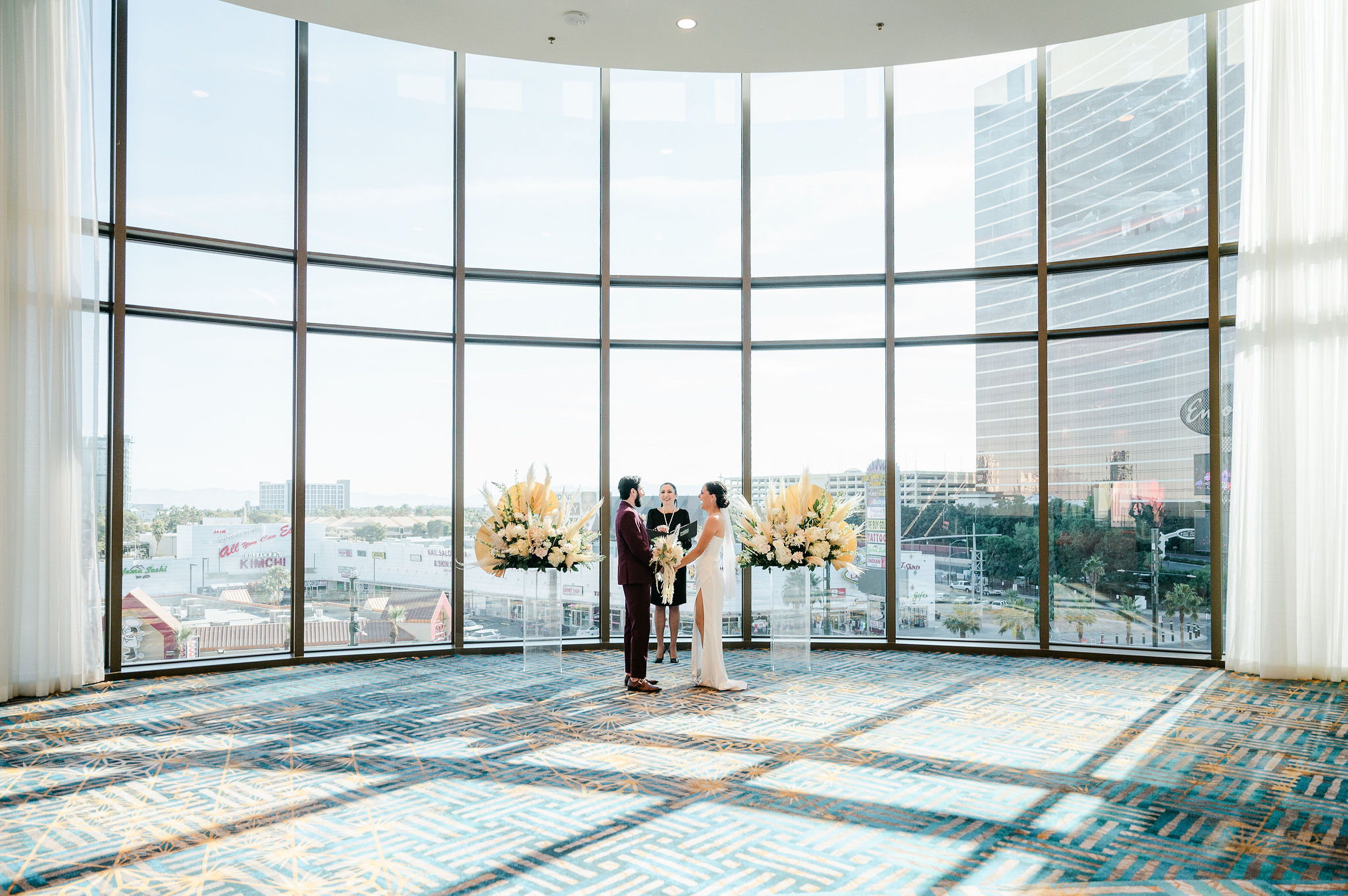 Bride and groom holding hands in front of officiant at the District Overlook in Las Vegas