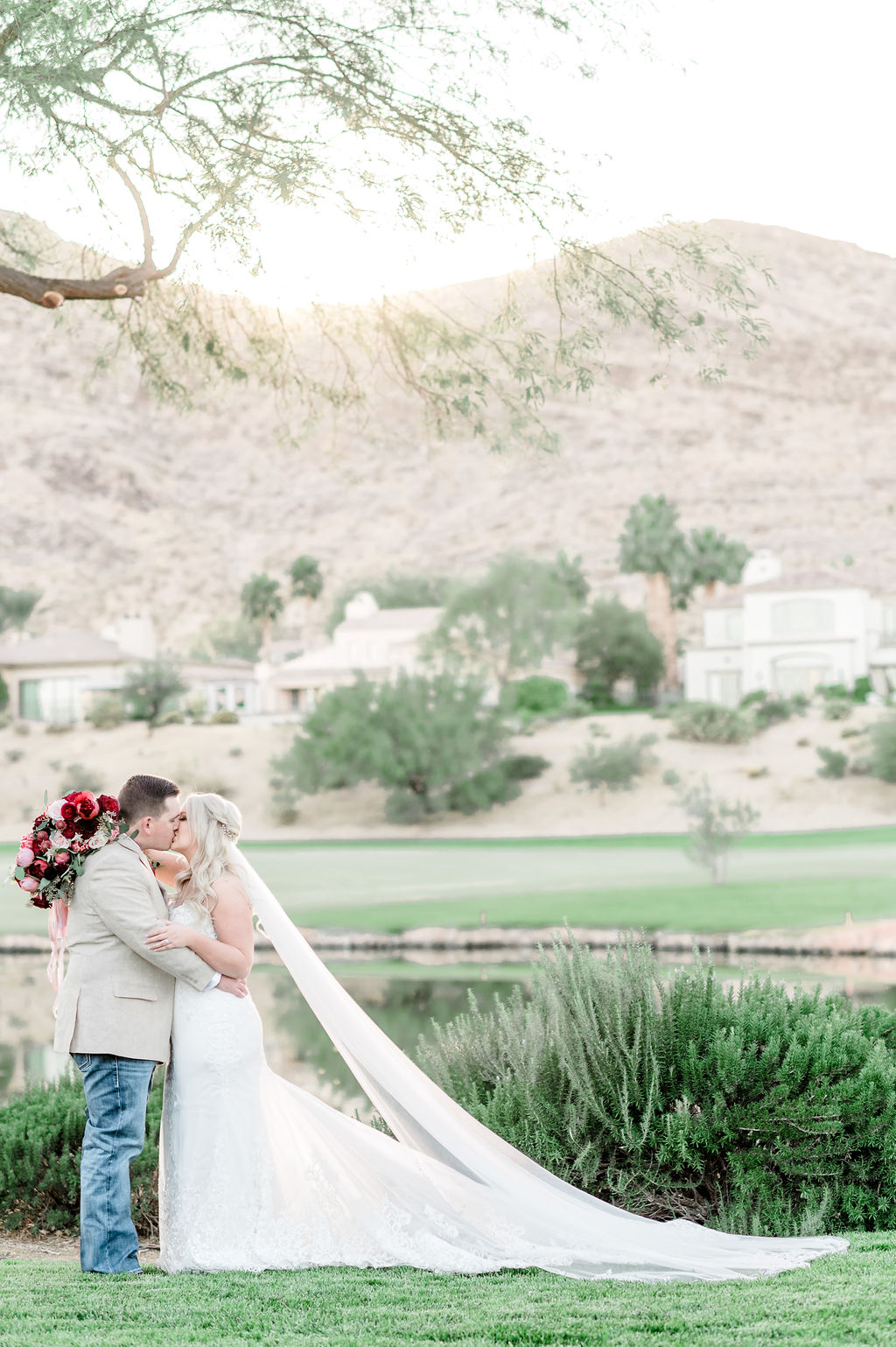 Bride and groom sharing an embrace as they wrap their arms around each other during their Red Rock Country Club wedding shoot