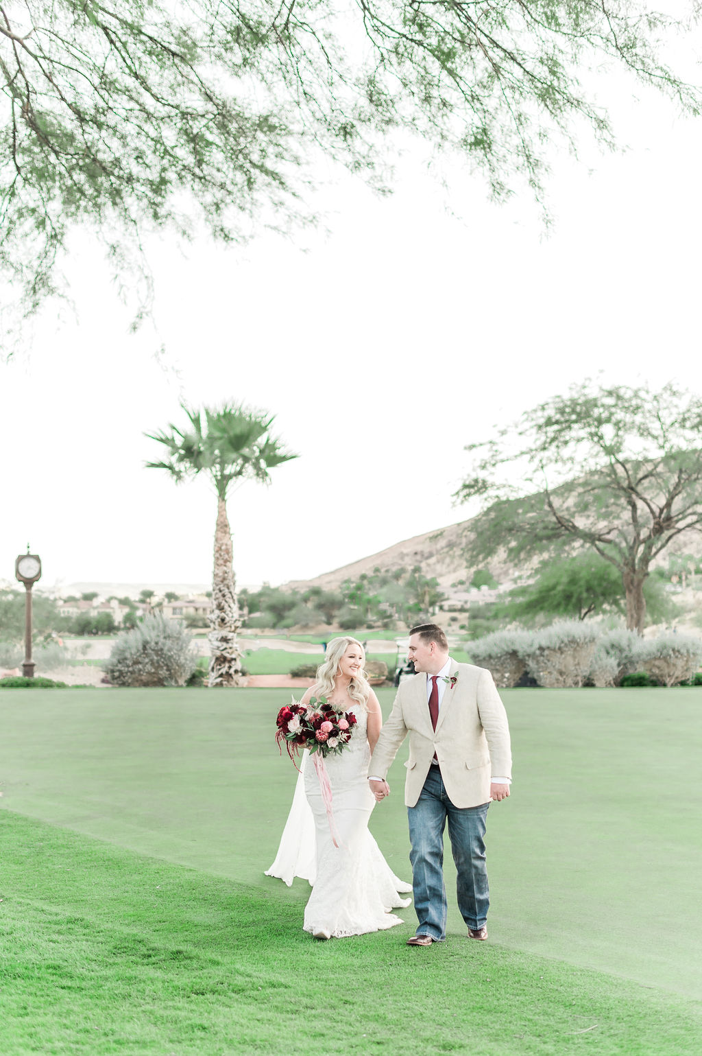 Bride and groom smiling at each other as they hold hands during their shoot arranged by Elopement Las Vegas