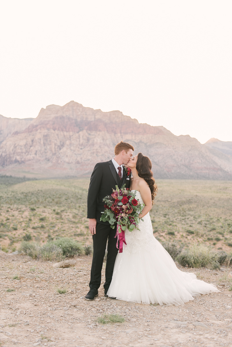 Red Rock Country Club Wedding: A  Complete Guide. Couple sharing a kiss during their wedding shoot.