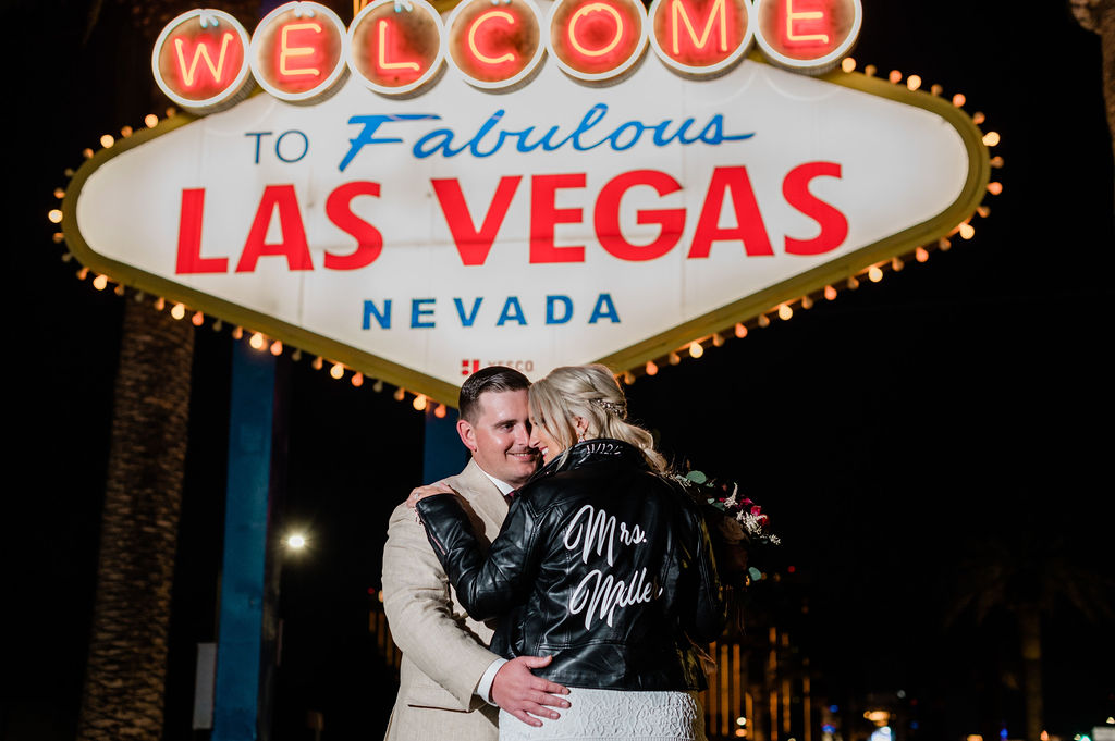 Couple sharing a dance in front of Las Vegas sign during their wedding reception