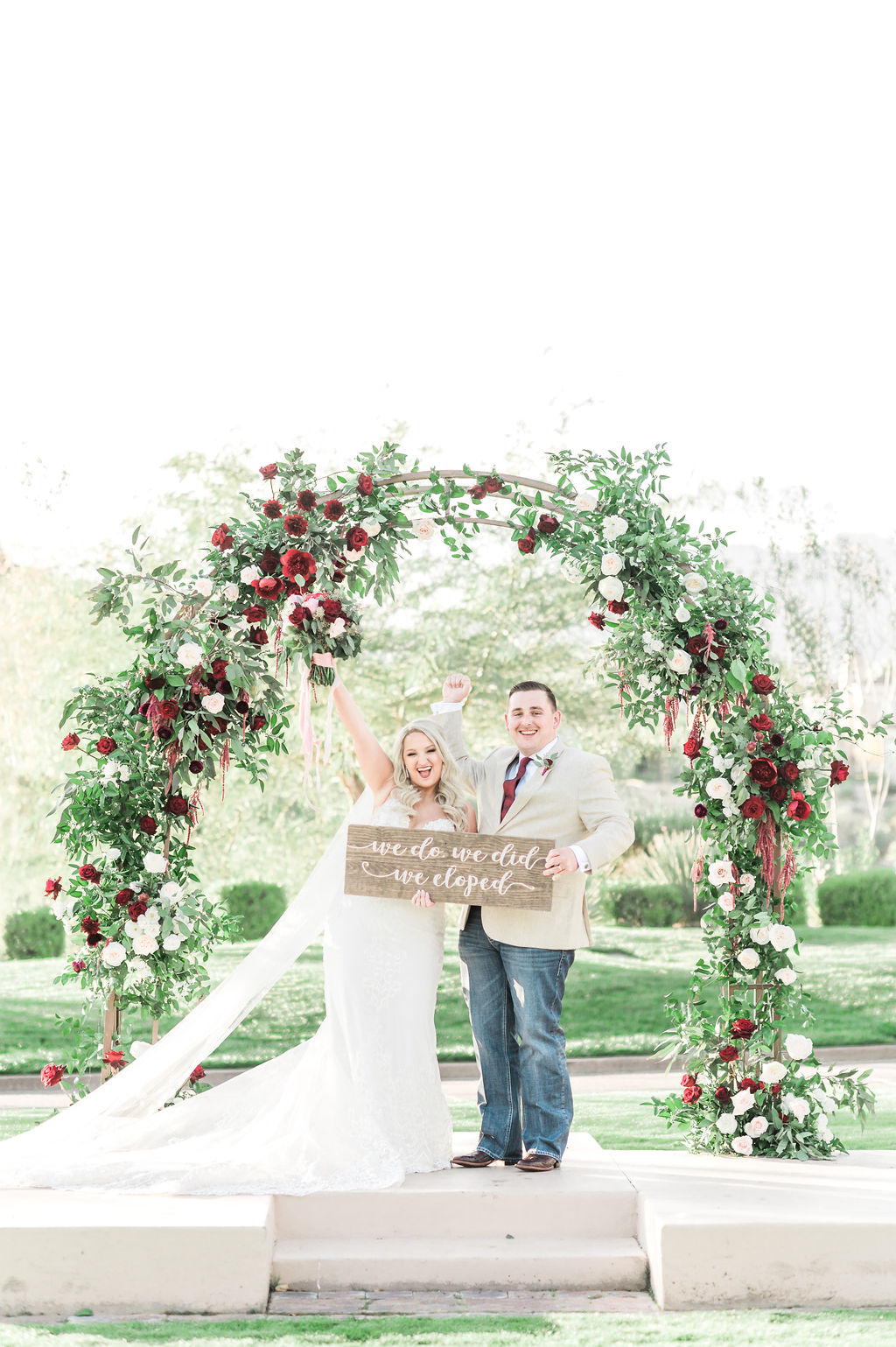 Newlywed couple holding up We Eloped sign during their wedding shoot arranged by Elopement Las Vegas