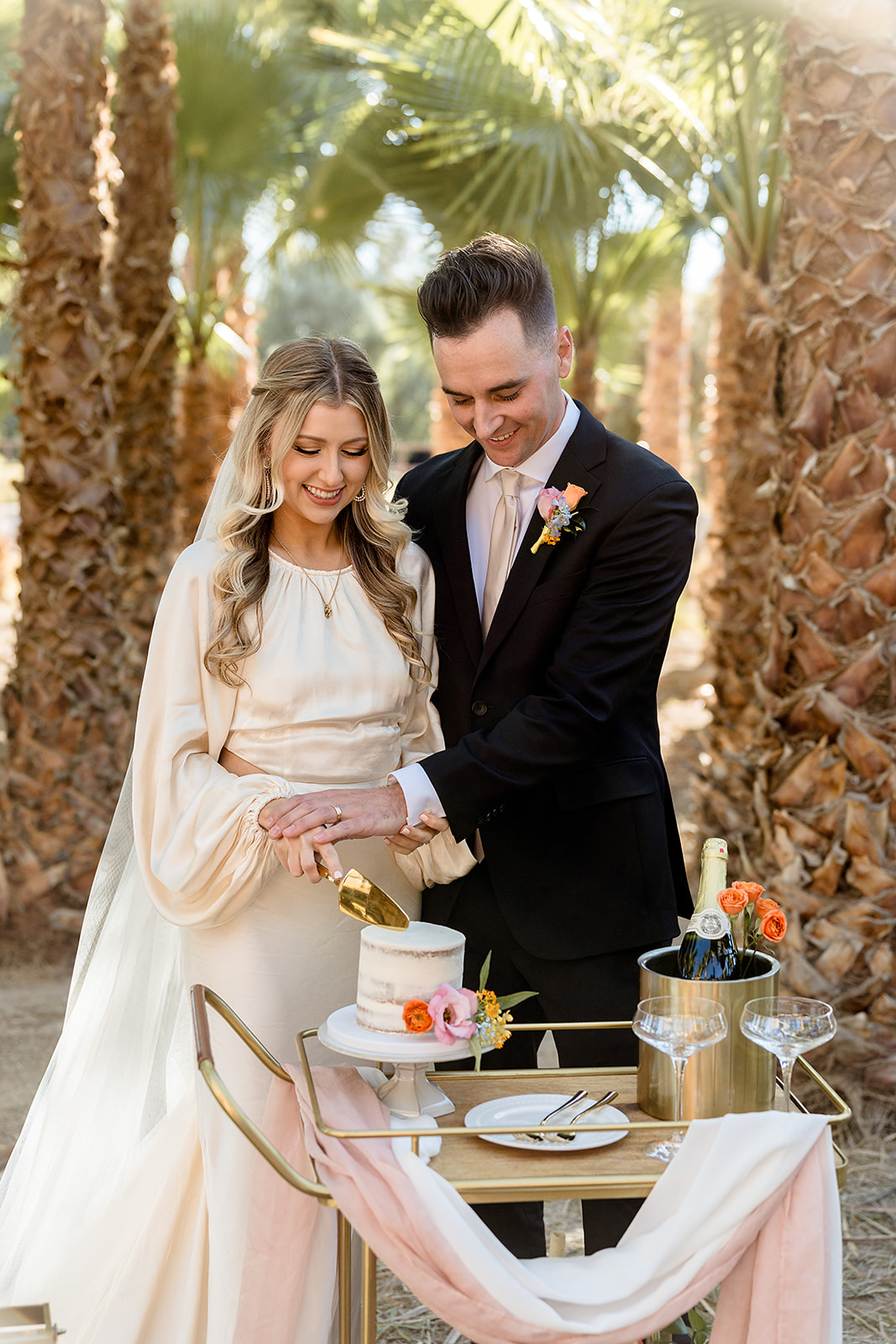 Newlywed couple smiling as they cut a slice of their wedding cake during their Las Vegas Elopement