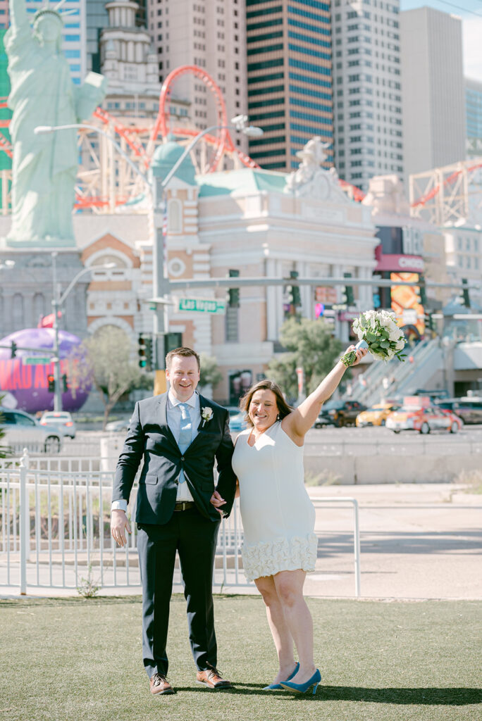 Las Vegas Boulevard Wedding and Elopement: Everything You Need to Know. Bride and groom holding hands while posing during their wedding shoot.