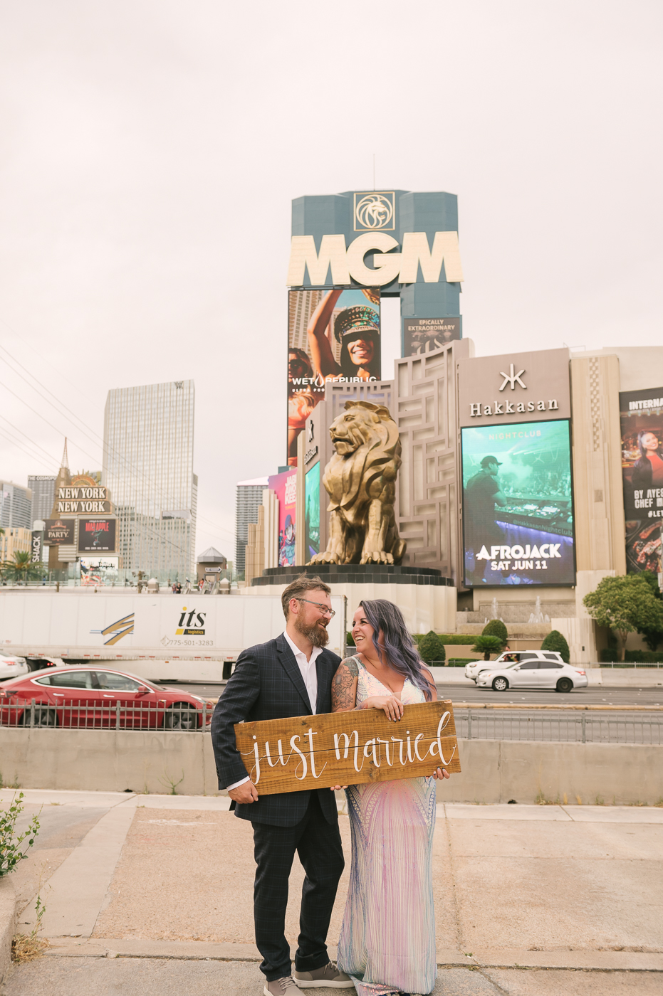 Bride and groom holding up Just Married sign during their wedding shoot arranged by Elopement Las Vegas