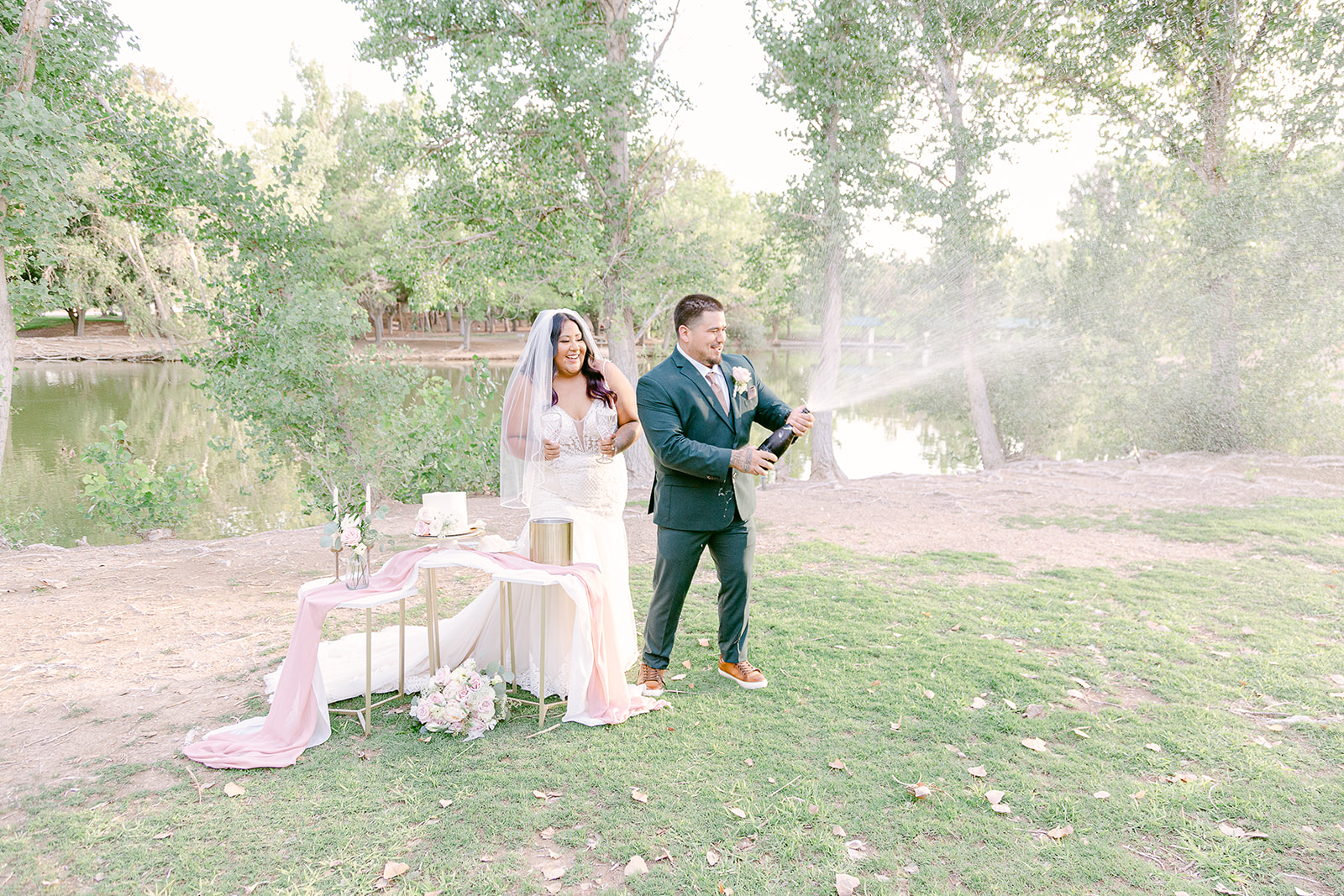 Bride and groom opening up a bottle of champagne during their Tule Springs elopement
