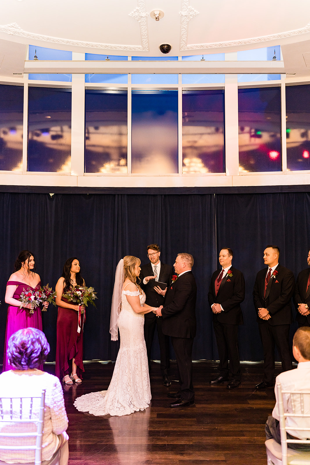 Bride and groom holding hands in front of the officiant during their elopement in Las Vegas