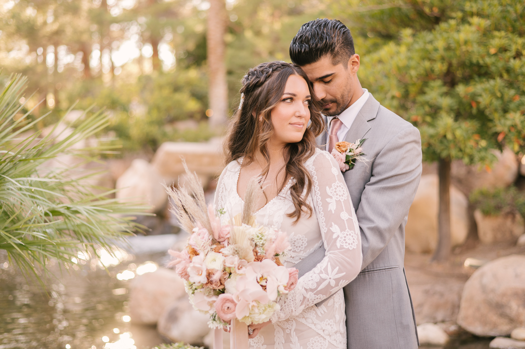 JW Marriott: Las Vegas Wedding Planning Guide. Groom hugs bride from behind during their wedding shoot.