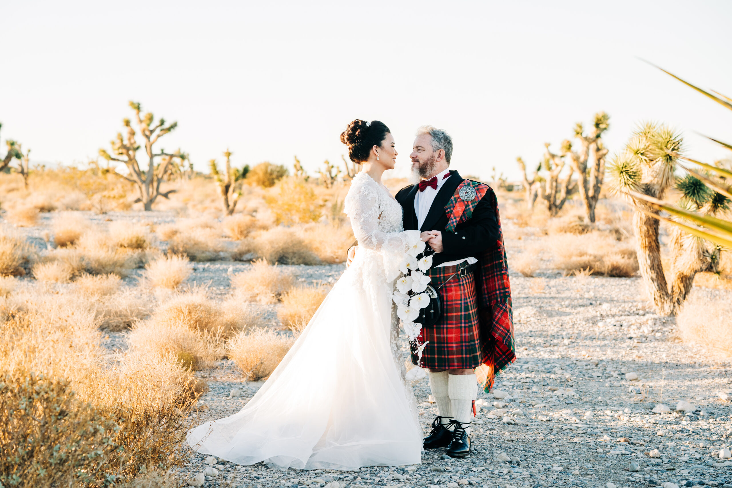 Newlywed couple smiling as they share an embrace during their elopement shoot arranged by Elopement Las Vegas