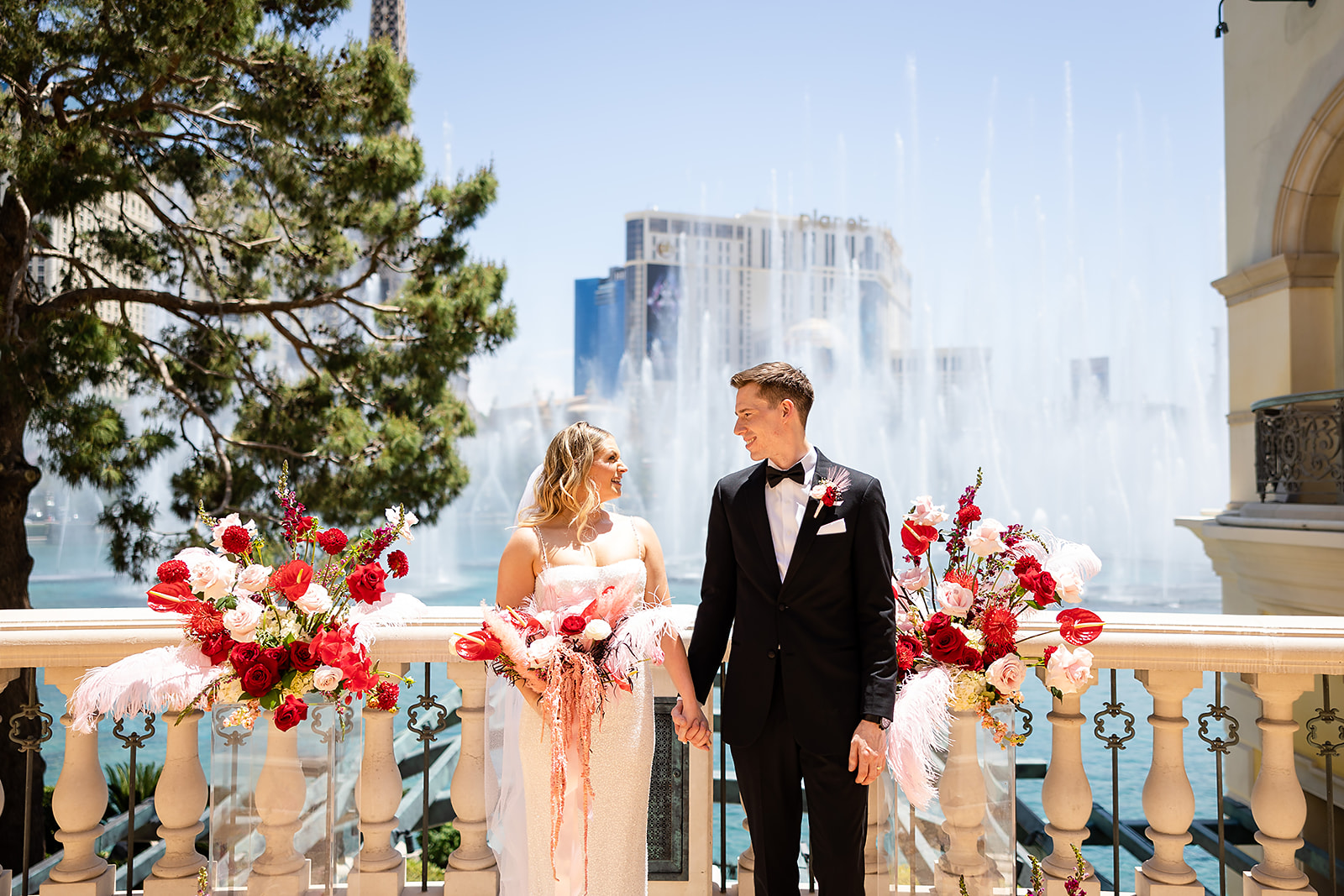Bride and groom holding hands in front of fountain during their Las Vegas elopement