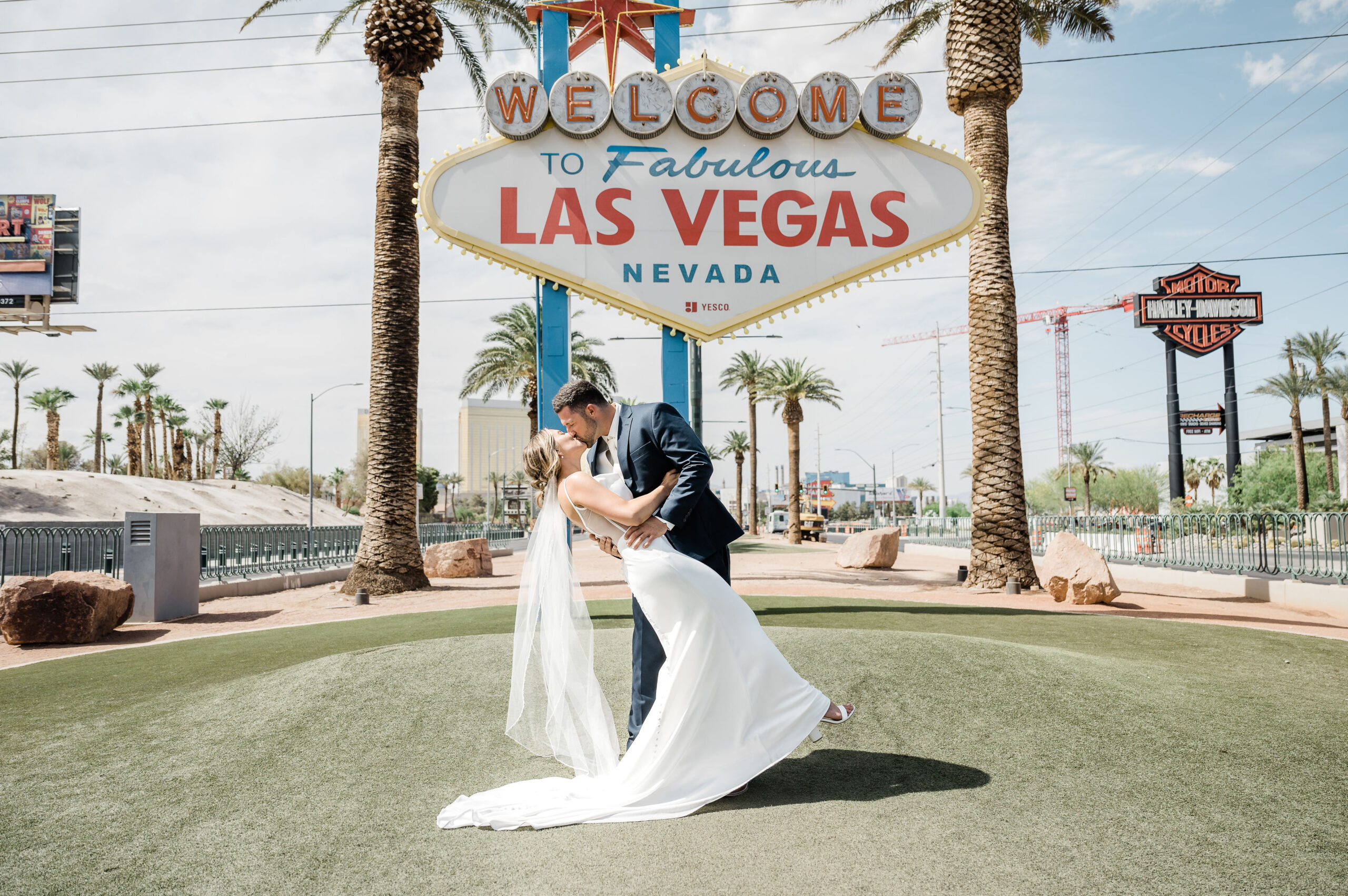 What Documents Do I Need To Get Married In Vegas? Bride and groom sharing a kiss in front of Las Vegas welcome sign.