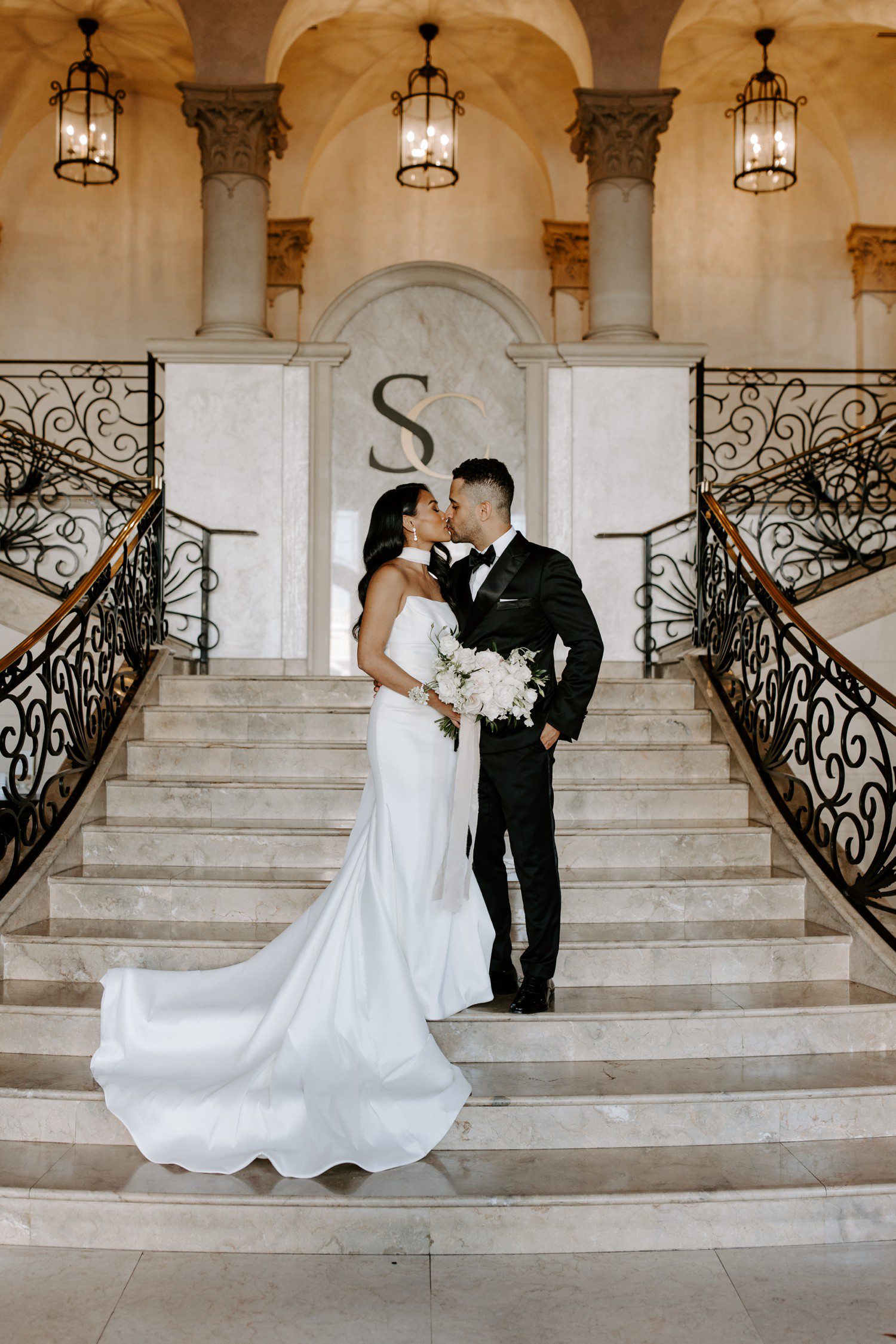 Bride and groom sharing a kiss on the stairs of The Stirling Club in Las Vegas